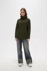 Polera de tejido de punto con cuello alto, diseño holgado y mangas largas. Presenta una textura de relieve tipo waffle en color natural.