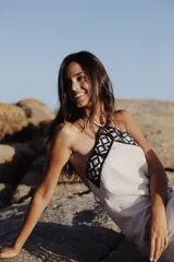 Vestido largo de lino en color beige, con escote halter y detalle de guarda pampa bordada en cuero en la parte superior.