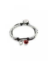 Pulsera Uno de 50 con doble tira, una de cuero marrón y otra de cuentas plateadas. Incluye un dije de corazón plateado y un dije de cristal de Murano rojo.
