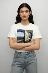 Remera de algodón de manga corta y cuello redondo, con estampado artístico en el pecho que representa un paisaje interior con vista al mar.