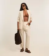 Pantalón celeste de corte recto, confeccionado en tejido de lino y viscosa. Presenta cintura elástica con lazo ajustable, bolsillos laterales y pliegues frontales.