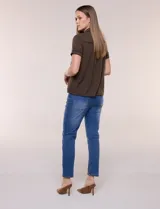 Camisa de manga corta color marrón oscuro, con cuello camisero, alforzas verticales, detalles de puntilla calada y frunces bajo el busto. Cuenta con cierre frontal de botones.