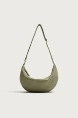 Bolso de hombro tipo hobo color verde militar, confeccionado en tejido de nylon, con compartimento principal y bolsillo interior con cierre de cremallera. Cuenta con asa de hombro ajustable.