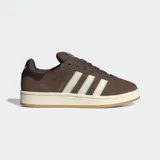 Championes Adidas Campus 00s de color marrón, confeccionados en cuero con las icónicas tres tiras dentadas en color blanco. Presentan una suela de caucho en tono crema y detalles en dorado, con un diseño inspirado en la cultura urbana y el skate de los años 2000.
