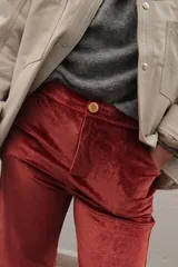 Pantalón de terciopelo color naranja, de corte recto y tiro medio con cierre frontal de botón y bolsillos.