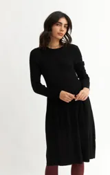 Vestido tejido azul marino de corte a la rodilla, con cuello redondo y mangas largas.