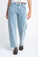 Jean de corte baggy con tiro medio, confeccionado en algodón peinado de tono celeste claro. Presenta un diseño de pierna amplia con costuras reforzadas en la zona de las rodillas.