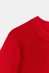 Jersey de punto de color rojo, cuello redondo y mangas cortas de corte ancho.