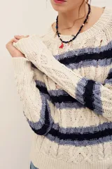 Sweater de punto con rayas horizontales en tonos beige y azul marino, manga larga y cuello redondo.