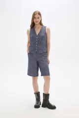 Chaleco azul sin mangas con cuello en V y cierre frontal con botones.