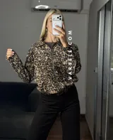 Campera bomber de gamuza con textura de corderoy, con estampado animal print de leopardo, cuello camisero, cierre frontal completo y bolsillos delanteros.