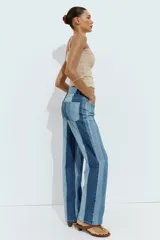 Jeans de tiro medio y pernera recta con diseño de rayas verticales en diferentes tonos de denim. Cuenta con cinco bolsillos y cierre frontal con cremallera y botón.