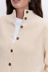 Cardigan de punto acanalado en color bordó, con cuello polo y cierre frontal de botones. Presenta un diseño de hombros caídos y mangas largas con puños ajustados.