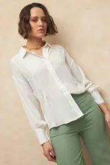 Pantalón de lino color verde, de tiro alto, con bolsillos en el frente y atrás, y corte recto.