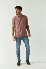 Polo de manga corta color rosado con estampado de pequeños puntos blancos. Presenta cuello y tapeta con botones.