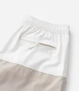 Bermuda de baño de microfibra con diseño bicolor, cintura elástica con cordón ajustable, bolsillos laterales y bolsillo trasero con cierre.