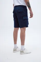 Bermuda cargo de corte recto con estampado de camuflaje en tonos verde y marrón. Cuenta con bolsillos laterales y bolsillos cargo con solapa y botones.