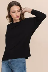 Remera negra de tejido rib con cuello redondo y mangas largas.
