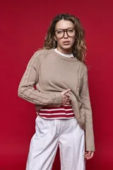 Sweater de tejido de punto negro con tramas de ochos en las mangas y laterales, cuello redondo a la base y mangas largas.
