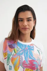 Remera blanca de algodón con estampado de flores y frutas en colores vibrantes.