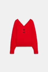 Jersey de punto color rojo con cuello en pico pronunciado y manga larga. Presenta cierre frontal parcial con dos botones y acabados en rib en puños y ruedo.