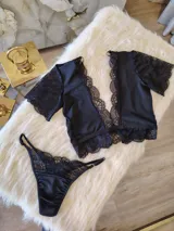 Conjunto de lencería compuesto por un top de encaje y microtul con escote profundo y una tanga regulable a juego. El top presenta mangas cortas de encaje y detalles de puntilla, mientras que la tanga combina microtul y encaje con forro de algodón.