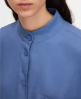 Camisa de lyocell color azul con cuello mao, botonadura frontal, manga larga con puño abotonado y un bolsillo en el pecho.