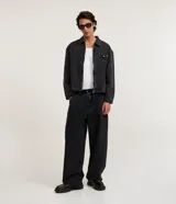 Pantalón masculino super baggy de jean color negro con efecto marmoleado, de corte amplio y recto, con cintura con trabillas, bolsillos y cierre tradicional.