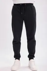 Pantalón deportivo tipo jogger color negro con tejido interior afelpado, corte clásico y cintura elástica.