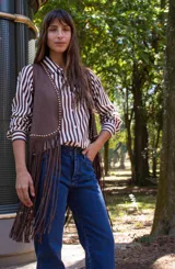Chaleco de estilo boho confeccionado en cuero sintético color marrón, con flecos largos en el ruedo y detalle de tachas metálicas a lo largo de los bordes frontales.