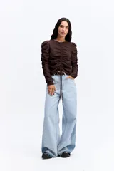 Blusa de manga larga color marrón chocolate, con diseño fruncido central ajustable mediante cordones y mangas con detalle de frunces laterales que aportan volumen.