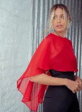 Capa corta de microtul color rojo, con diseño versátil que permite diversas formas de uso, ideal para complementar looks de fiesta.