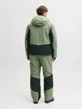 Campera técnica impermeable y cortaviento con capucha ajustable, diseñada para condiciones de frío, viento y lluvia. Confeccionada en tejido resistente, cuenta con cierre frontal con tapeta, bolsillos con cierre, ventilación bajo los brazos y ajustes en puños para evitar la entrada de nieve.