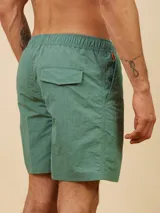 Short de baño de color liso con cintura elástica ajustable mediante cordón y detalle de parche con logo en la parte inferior.