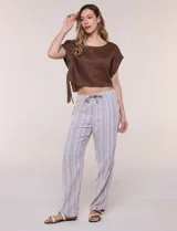 Pantalón de lino de calce holgado y caída ligera, con estampado de rayas verticales en tonos celestes y blancos. Cuenta con cintura elastizada fruncida con cordón ajustable al frente, bolsillos laterales y pierna recta.