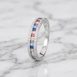 Anillo de plata con diseño de medio sin fin, engastado con circonias rectangulares en tonos multicolor y bordeado por pequeñas circonias blancas.
