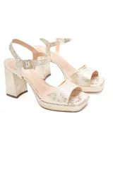Sandalias de cuero color blanco con estampado dorado tipo safari, con taco de 10 cm y plataforma de 2 cm. Tiras sin costuras y cierre de hebilla en el tobillo.