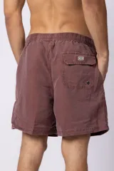 Short de baño de corte clásico con cintura elástica y cordón ajustable. Presenta un acabado efecto lavado vintage, bolsillos laterales y un pequeño logo bordado en la parte inferior.
