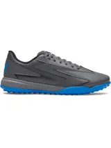 Championes de fútbol Under Armour Shadow Turf 3, diseñados para césped artificial. Presentan una parte superior sintética gris con detalles en azul, entresuela Charged Cushioning para amortiguación y suela de goma con tacos estratégicos para máximo agarre.