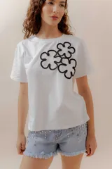 Short de jean celeste con tachas metálicas plateadas, tiro medio, terminaciones desflecadas, cierre frontal y bolsillos funcionales.