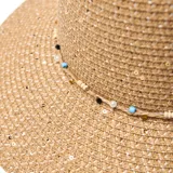 Sombrero de paja color beige con ala ancha y banda decorativa con cuentas de colores.