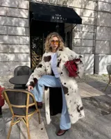 Tapado midi de piel sintética con estampado de manchas tipo vaca en tonos blanco y marrón. Presenta cuello amplio, cierre frontal con botones y corte recto de ajuste relajado.