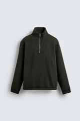 Sudadera de corte relajado confeccionada en tejido con textura. Presenta cuello subido con cierre frontal de cremallera metálica y manga larga.