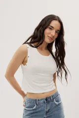 Top crop negro de calce ajustado, con escote redondo, diseño sin mangas y detalles de ojales metálicos decorativos en los hombros.