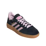 Championes Adidas Handball Spezial de corte bajo, confeccionados en gamuza negra con detalles en rosado en las icónicas tres tiras, cordones y talón. Presenta una suela de caucho color caramelo y el logo de la marca en dorado en el lateral.