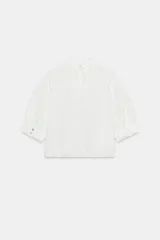 Camisa rosa de cuello alto, mangas cortas abullonadas y detalles de encaje y entredós en el frente y las mangas.