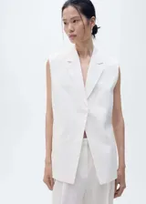 Chaleco tipo blazer sin mangas, de corte oversize y cuello con solapas. Confeccionado en lino, presenta un diseño abierto sin cierre y dos bolsillos laterales de ribete.