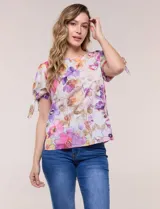 Blusa de gasa liviana con estampado floral en tonos violeta y rosado, cuello redondo y mangas cortas con detalle de lazo en los puños.