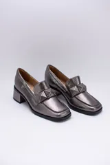 Mocasines plateados de cuero con aplique geométrico al tono y taco cuadrado.