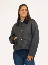 Campera de algodón encerado con cuello de pana en contraste, cierre frontal con botones y bolsillos delanteros tipo cargo.